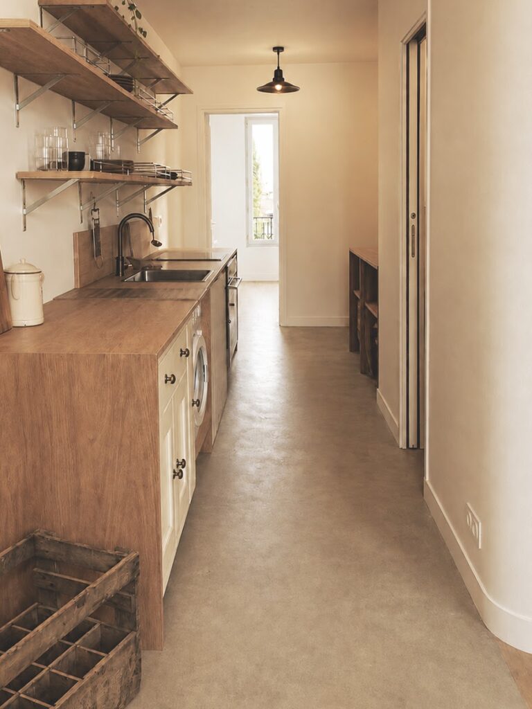 Cuisine en longueur, mobilier et étagères en bois.